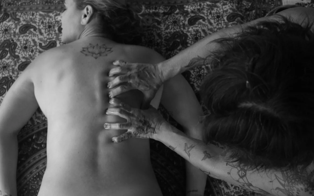 Radha applying therapeutic bodywork to a client's back